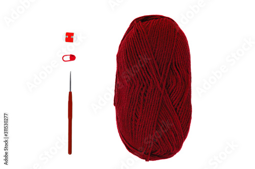 Knitting and crocheting flatlay.Burgundy yarn skein, crochet hook, row counter on white background isolated. Knit hat process.Accessories, stitch markers tools. Red wool. Thread hank, handmade craft.