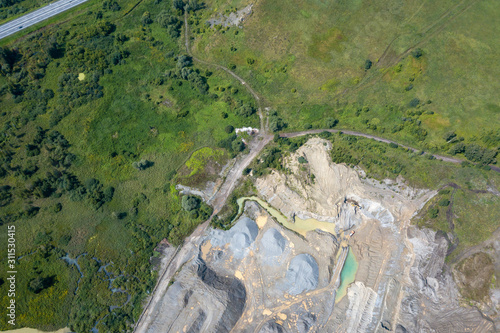 Aerial view of a small plant for the production and cleaning rubble and cement near the heaps of building materials, the tractors and trucks transports the finished product. Mining in quarry.