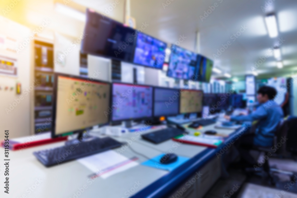Blurred of man engineer works with the tablet in the production control room.Control room of a steam Turbine,Generators of the coal-fired power plant for monitor process, business and industry concept