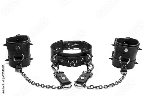 Black BDSM collar with spikes and leather bracelets on his hands