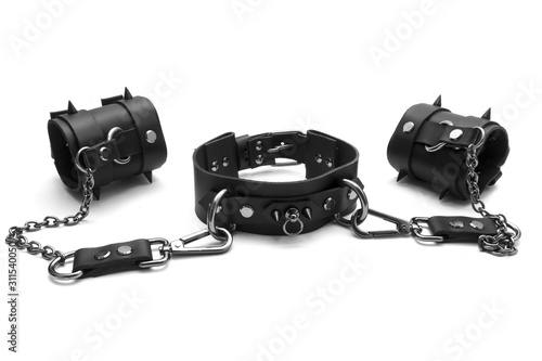Black BDSM collar with spikes and leather bracelets on his hands