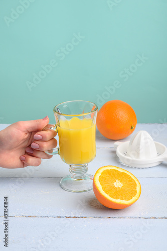 Oranges, a transparent glass and a juicer.Summer mood and vitamins.