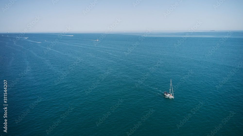Aerial view of sailing Yacht in open sea at windy day. Drone photo of luxury sail boat cruising in the deep blue Aegean sea, Greece Aerial view of sailing Yacht in open sea at windy day. Drone photo of luxury sail boat cruising in the deep blue Aegean sea, Greece