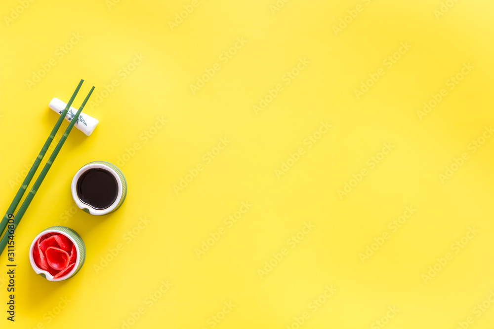 Set of chopsticks for sushi, ginger and soy sause on yellow background top-down frame copy space Set of chopsticks for sushi, ginger and soy sause on yellow background top-down frame copy space
