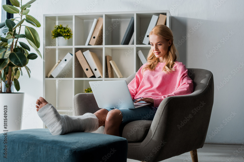 attractive and injured woman working from home with laptop attractive and injured woman working from home with laptop