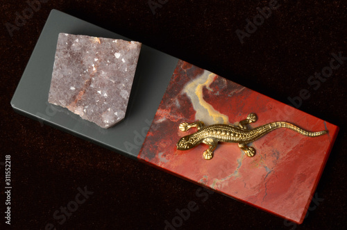 Jasper and quartz: a plate of the red jasper stone, with a golden lizard above, and the crystalline rocky quartz; a polished object 37*108 mm. Jasper and quartz are beautiful ornamental minerals photo