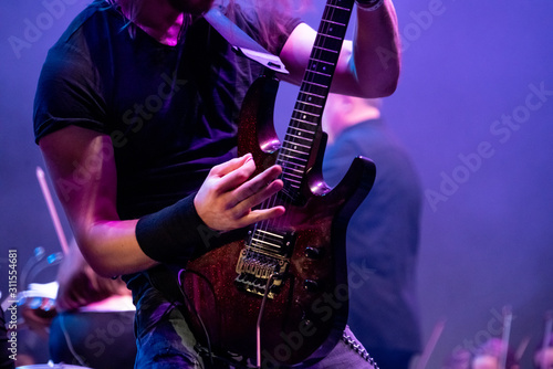 Man playing electric guitar on the stage at the rock concert photo