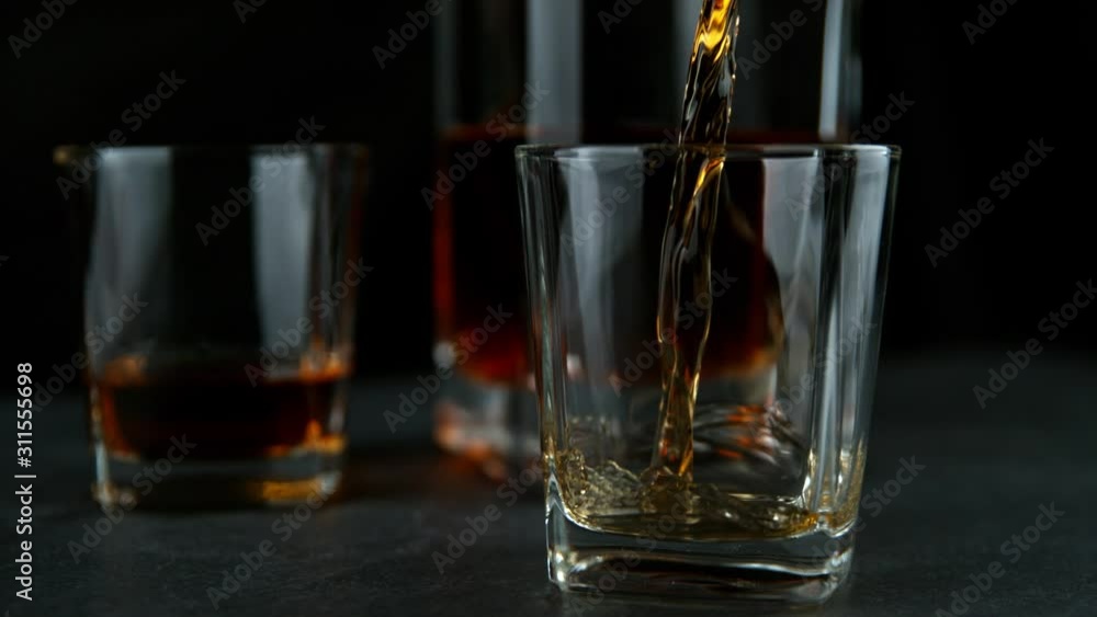 Super Slow Motion Shot of Pouring Whiskey into Glass at 1000fps with Camera Movement. Super Slow Motion Shot of Pouring Whiskey into Glass at 1000fps with Camera Movement.