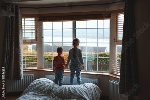 children looking through window at room