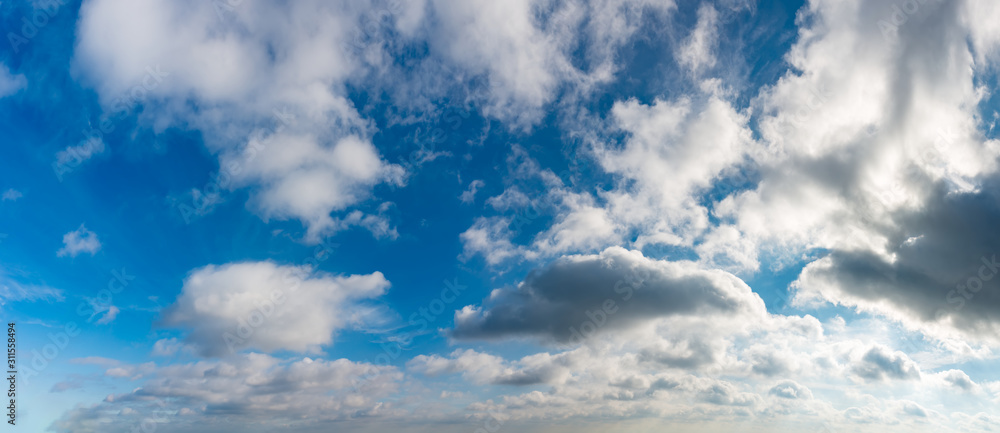 Fantastic clouds against blue sky, panorama