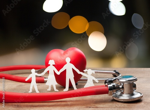 Family cut-out and stethoscope on wooden desk, Medical Insurance Concept