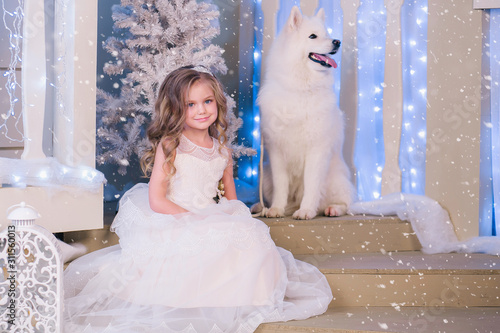 Nice girl in a white dress in Christmas decorations