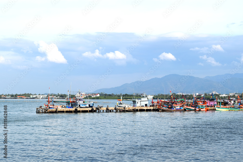 The atmosphere of fishing boats on the coast of Pattaya, Thailand with good weather, clear sky.