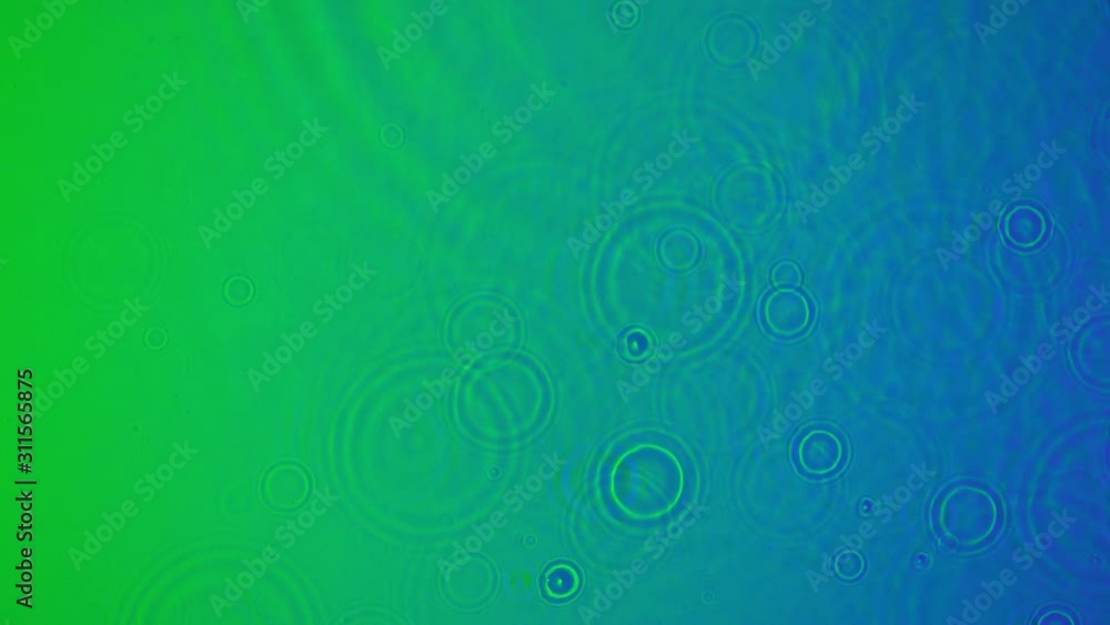 Super Slow Motion Shot of Water Droplets Falling into Neon Water at 1000fps.