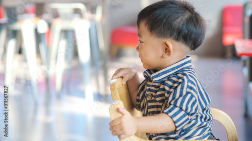 Adorable infant boy sitting on child chair wait food