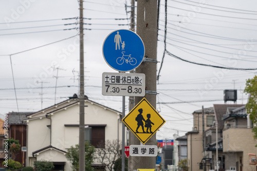 Translation of top sign: "Bicycle, Saturday, Sunday, Holiday 7:30am - 8:30 am".Translation of bottom sign: "School Zone"