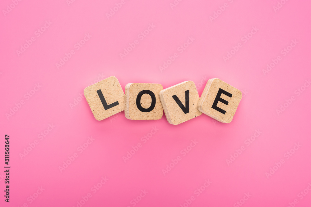top view of love lettering on wooden cubes isolated on pink top view of love lettering on wooden cubes isolated on pink
