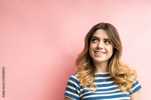 Thoughtful Young Woman Against Plain Background In Studio