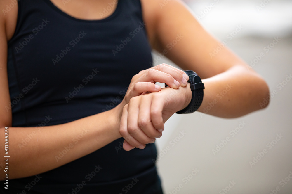Close-up of woman using fitness smart watch device after running