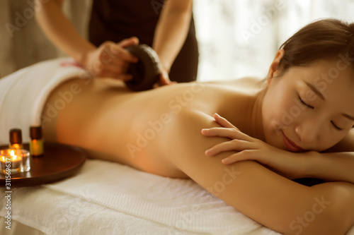 Masseur is massaging woman back in spa