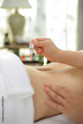 A drop of essential oil for a spa conditioning massage on the waist