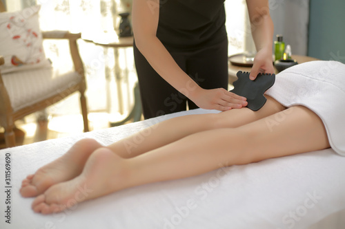 Beautician uses tools to massage the legs