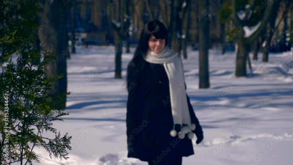 Pretty Brunette Female Walks Smiling In Snow Covered Park. Winter City Life Background. Slow Motion 30 fps 1/2 real time speed 60 fps Pretty Brunette Female Walks Smiling In Snow Covered Park. Winter City Life Background. Slow Motion 30 fps 1/2 real time speed 60 fps
