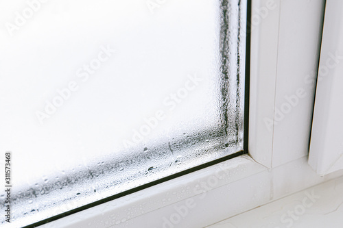 Plastic window with damp and water condensation on glass