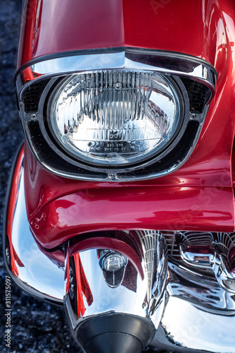 Cuadro en lienzo Closeup chrome headlight red classic 1950s nostalgic hot rod muscle car at car s
