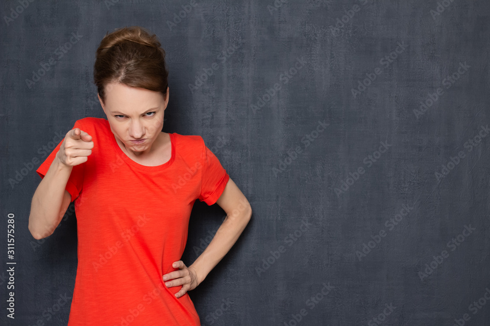 Portrait of angry furious girl pointing at you and making reprimand Portrait of angry furious girl pointing at you and making reprimand