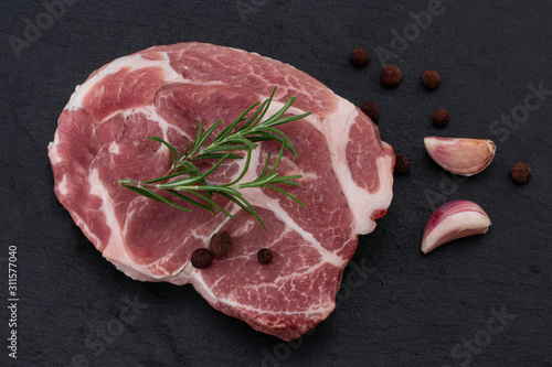 Raw meat,  steak with spices on black background