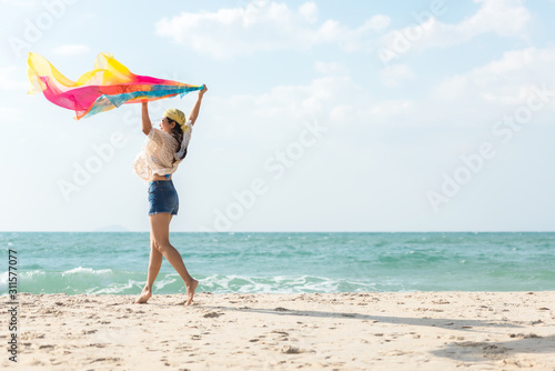 Summer Vacation.  Traveler women relaxing and joy fun on the beach, so happy and luxury and destination in holiday summer.  Tourism chill leisure on sand.  Travel Trips and lifestyle Concept. photo