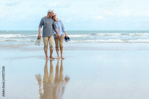 Lifestyle asian senior couple happy walking hug and relax on the beach. Tourism elderly family travel leisure and activity after retirement in vacations and summer.