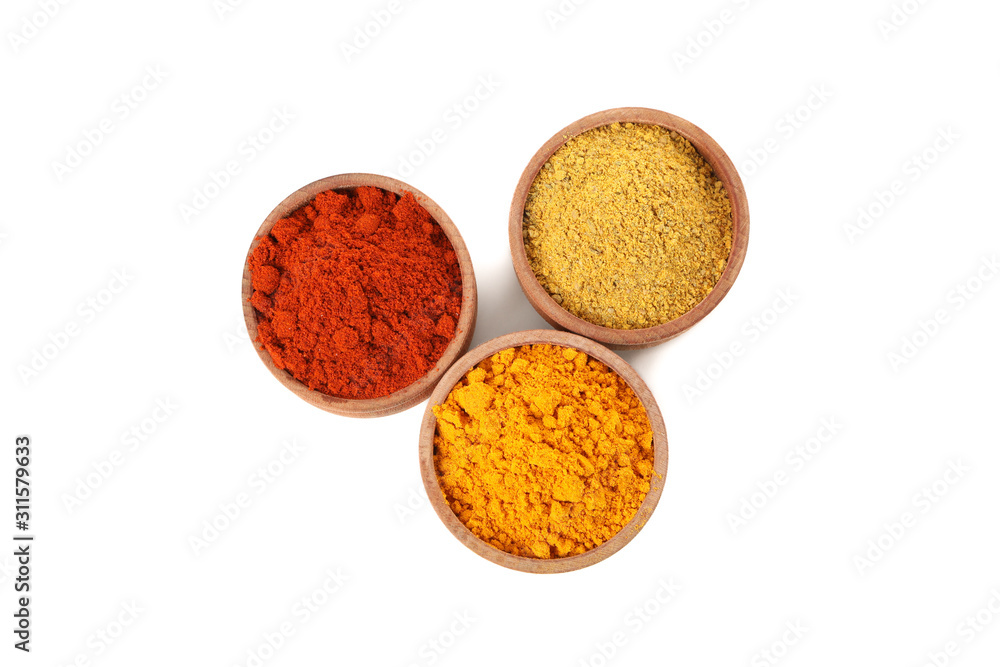 Wooden bowls with red pepper, curry and turmeric powder isolated on white background Wooden bowls with red pepper, curry and turmeric powder isolated on white background