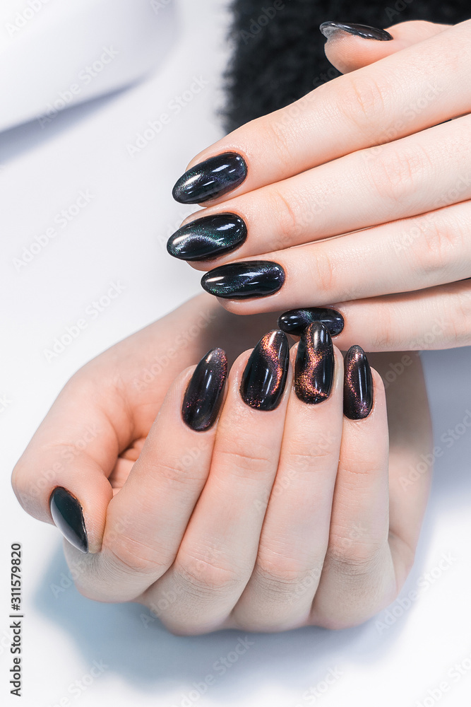 Closeup top view of professional colorful glossy brilliant holiday manicure  at fingers of young woman. Modern trendy shiny amazing cat eye effect nail  design. Vertical color photography. Photos | Adobe Stock