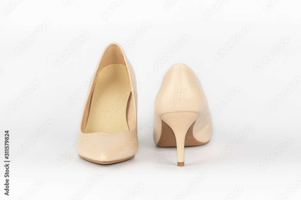 Fototapeta premium Pair of beige women's leather shoes on high-heeled isolated on white background. Concept for female shopping and fashion.
