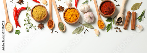 Spoons and bowls with different spices and ingredients on white background, space for text