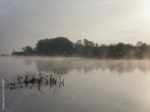 Mist over the water in the morning sun. Landscape.