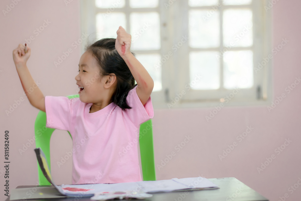 An Asian kindergarten girl is coloring on the table. An Asian kindergarten girl is coloring on the table.
