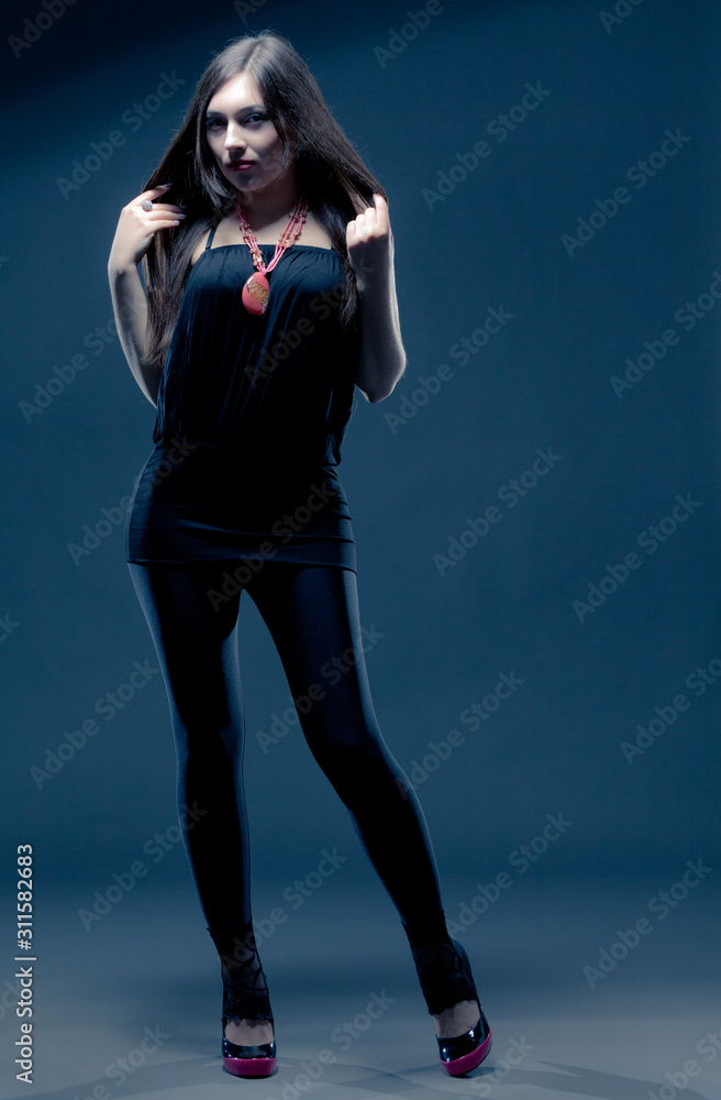 Young brunette woman in black casual clothing, shoes and massive accessories Young brunette woman in black casual clothing, shoes and massive accessories