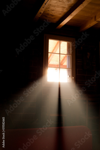 Basement windows in wooden cabin house. Light beams passing through them