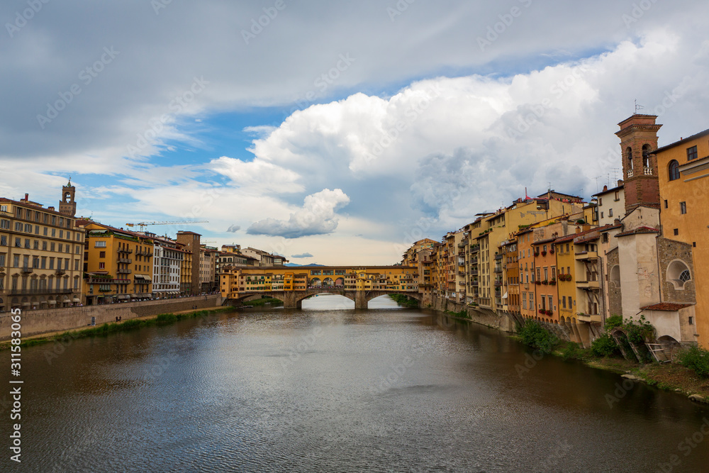Fototapeta premium The Ponte Vecchio, a medieval stone closed-spandrel segmental arch bridge over the Arno River, in Florence, Italy, noted for still having shops built along it. 