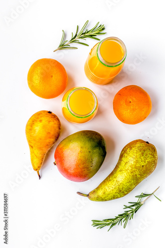 bottles of smoothie with fruits on white table top view