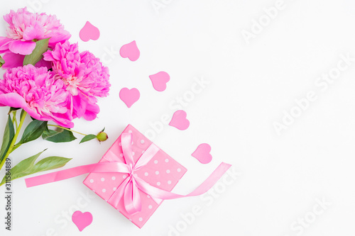 Flat lay valentines day frame with pink peonies and gift box on a white background