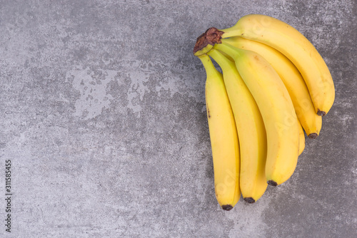 Ripe yellow bananas on a grey structured background,empty  copy space