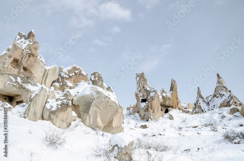 unique geological rock formations under snow in Cappadocia, Turkey.
