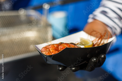 chef cooks shrimp at street food festival photo