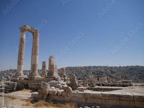 Roman ruins of the citadel of Amman, capitol of Jordan, remains of a city build from stone and tall pillars on a brown hill in the middle of a city