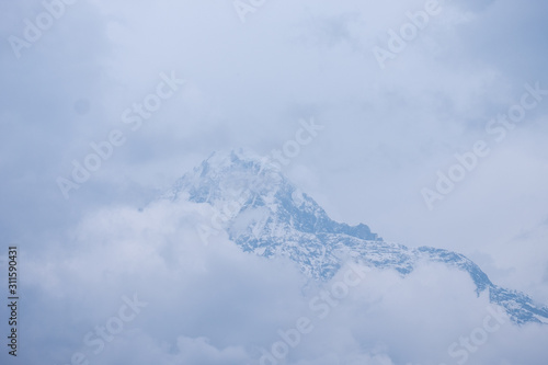 The holy mountain of Machapuchare with clouds