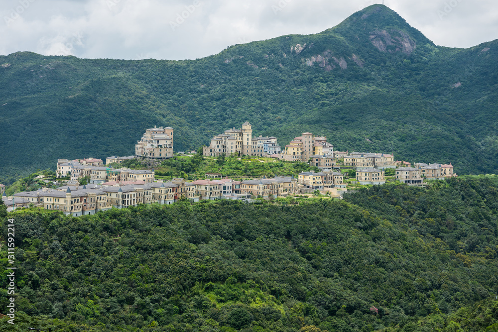 A beatiful castle in the valley and mountains background at Shenzhen Overseas Chinese Town East (OCT East) in Guangdong, China. A resort with themed parks: Knight Valley, Tea Stream and Wind Valley.
